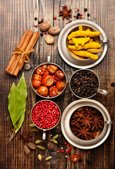 Spices in metal bowls on a wooden table, flat lay, top view