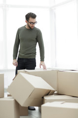 man looks at boxes in a new house