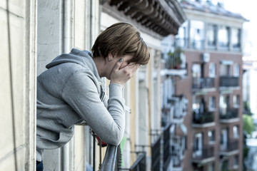 Unhappy woman suffering from depression feeling desperate, isolated, worthless on home balcony
