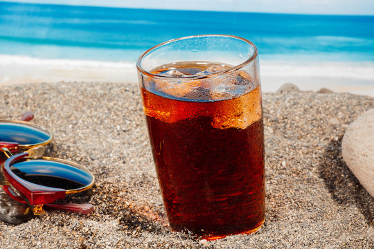 A cold drink in a glass on the beach, a delicious soft drink in the summer