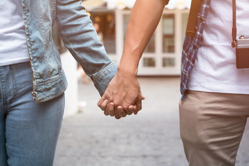 Young couple are holding hands and walking together.
