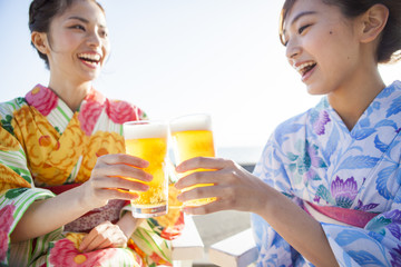 浴衣を着た女性たちは生ビールで乾杯している