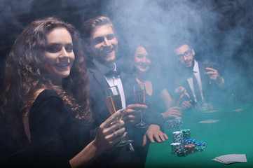 group of friends sitting at game table in casino