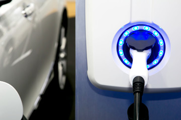 Power supply for electric car charging. Electric car charging station. Close up of the power supply plugged into an electric car being charged