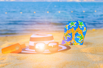 Summer vacation concept with accessories ,sand and sea as sun flare or lens flare background