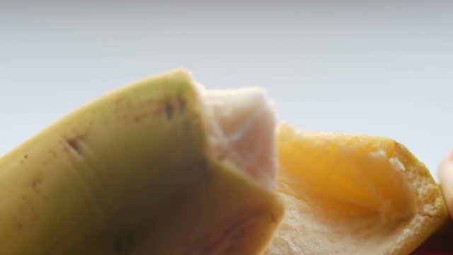 Woman sexually peel banana skin, macro close up view