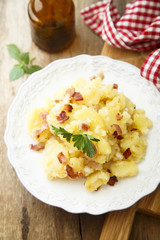 Potato salad with fried bacon and parsley