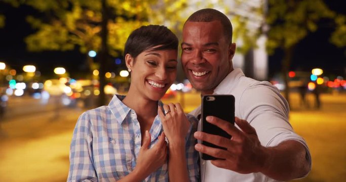 Joyful black couple takes selfies together after their recent engagement while on vacation in Paris, France, Newly engaged African male takes photos with his new fiance with her wedding ring, 4k