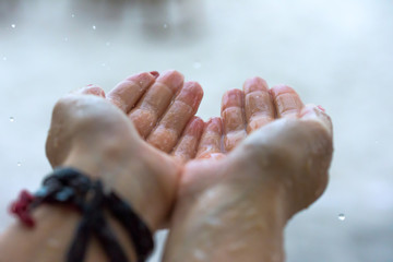 Rain drops falling on woman’s hand 