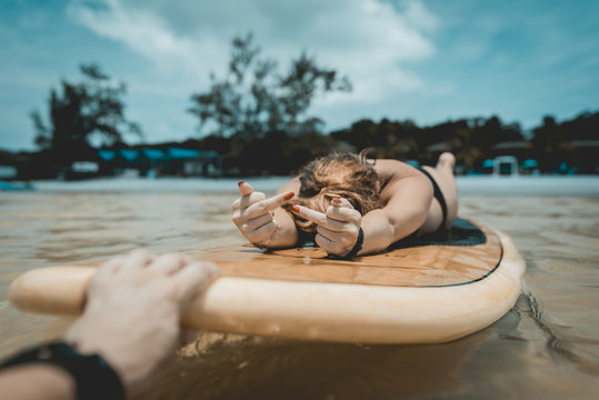Sexy girl swimming on paddleboard showing fuck you gesture. Koh Rong Samloem. Saracen Bay, Cambodia. 