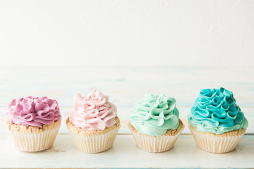 Four colorful cupcakes on a light background. Copy space