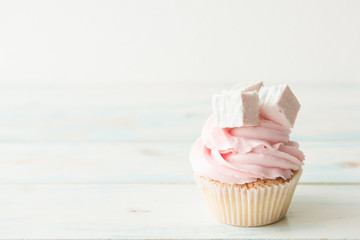 One cupcake on a wooden table. Copy space