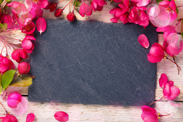 Spring background with slate board and flowers