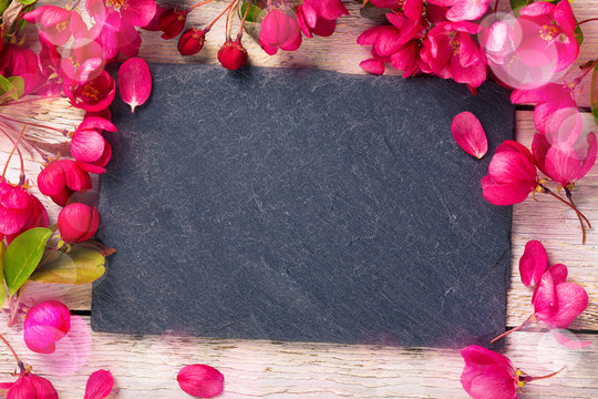 Spring background with slate board and flowers