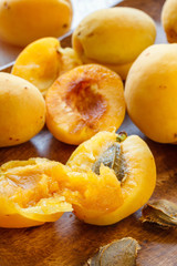 Whole and cut apricots on a wooden platter