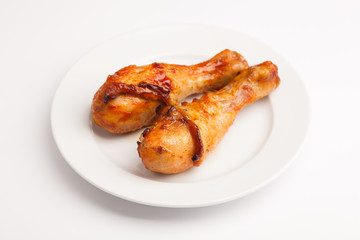 beautiful photo close-up menu of fresh delicious chicken legs on a plate on a white background
