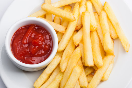 A beautiful photo of a closeup menu of fresh delicious french fries sauce on a plate on a white background