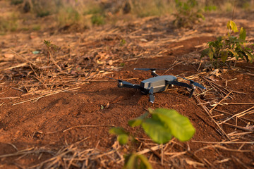  Modern professional quadro drone lies in the red ground ready to takeoff. 
