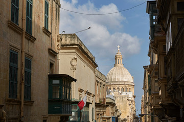 Fototapeta na wymiar Traditional narrow street and church in Valletta in Malta
