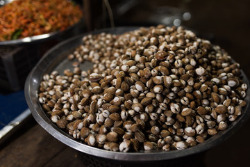 Cambodian night street food market with boiled   sea shell I iron bowl