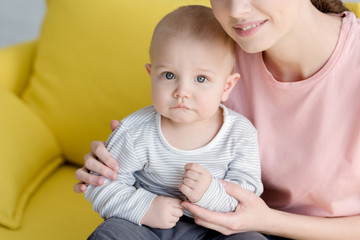 mother with little baby boy sitting on sofa