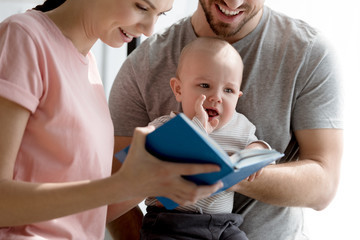 happy parents with son dearing book together