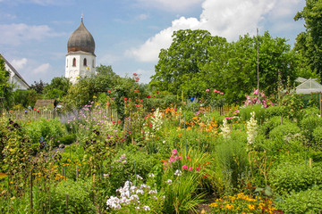 Idylle im Klostergarten des Klosters auf der Insel Frauenchiemsee, mit vielen bunten Blumen im...