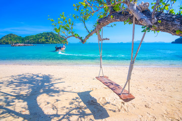 Relaxing with wooden swing under the tree on tropical beach, Scenery of beautiful destination, Koh Phakbia island, Andaman sea, Krabi province, Thailand.