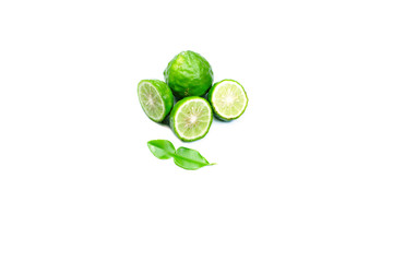 Obraz premium sliced young bergamot fruit and green leaves on white background isolated