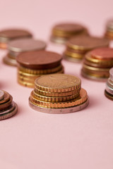 close-up shot of stacks of coins from various countries on pink