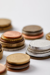 close-up shot of stacks of various coins on white