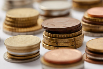 Close-up shot of stacks of coins from different countries on white