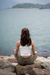 Fototapeta na wymiar Woman Meditating on Rock