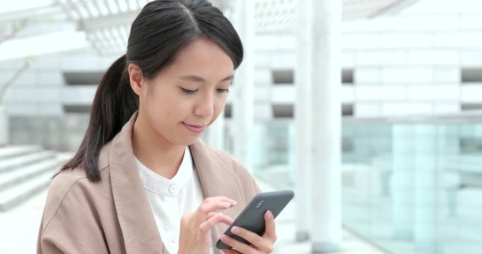 Woman using mobile phone in city at outdoor