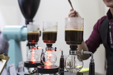 coffee preparation step by step. extraction process. Barista is pouring siphon into the flask from...