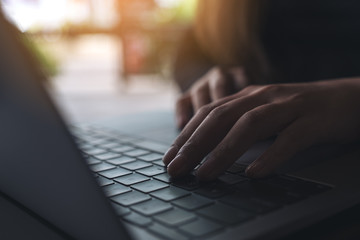 Closeup image of a business woman's hands working and typing on laptop keyboard