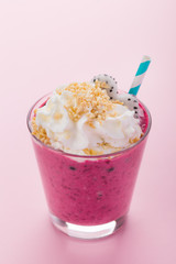 Smoothie in glass with berries on pink