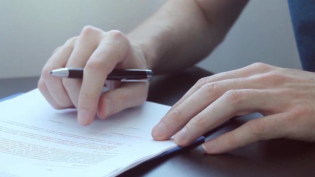 Signing income tax documents for 2018 and 2019 tax years with manual paperwork.