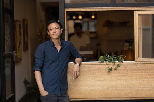 Portrait of man standing outside cafe