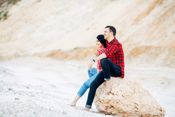 Beautiful couple sits and relaxs on a stone in a canyon. Romanticism. Travel concept. Copy space