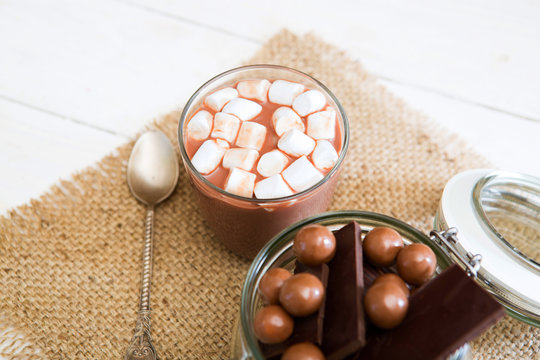 Chocolate milkshake with marshmallows on white wooden table