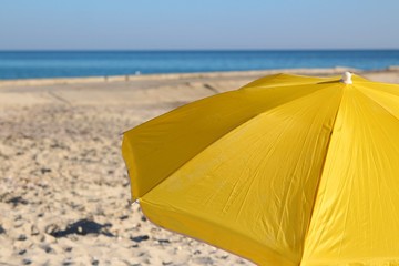 yellow beach umbrella on sea shore
