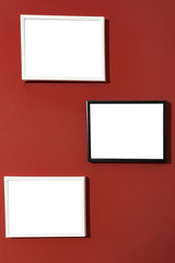 Black and white photo picture frames isolated white, blank painting frames on red wall.