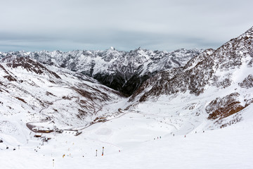 Snow on the mountains against the cloudy sky