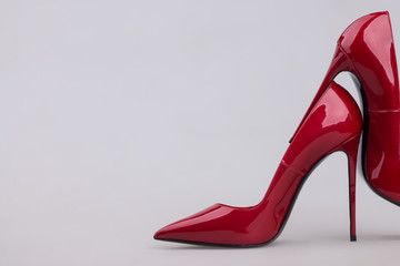 Women's red shoes with a varnish on a gray background