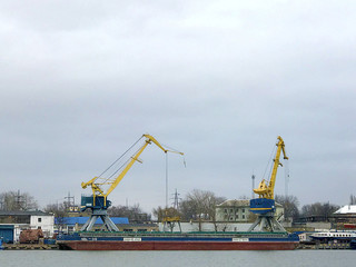 Ship cranes on the river bank.