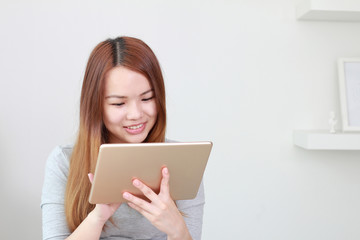 Young woman using tablet at home.