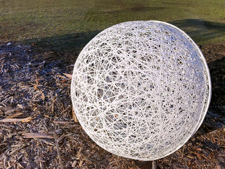 A large white fishnet souvenir ball on the ground.