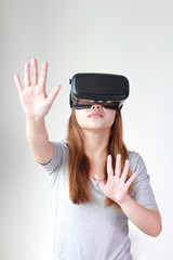 Young woman wearing virtual reality glasses at home.