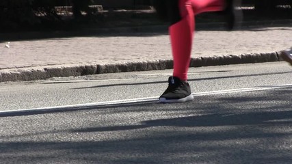 Marathon runners legs on asphalt road